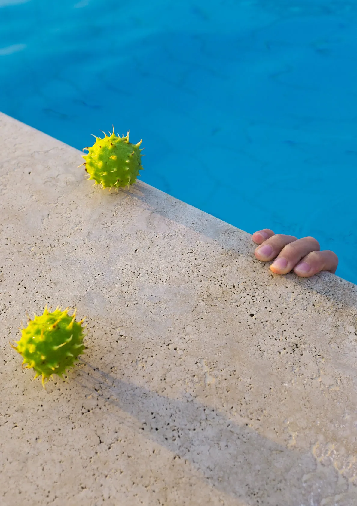 Beach dream / hand with tropical fruits in swimming pool